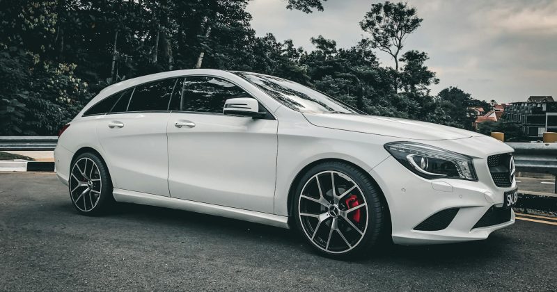 grayscale photo of sedan on road